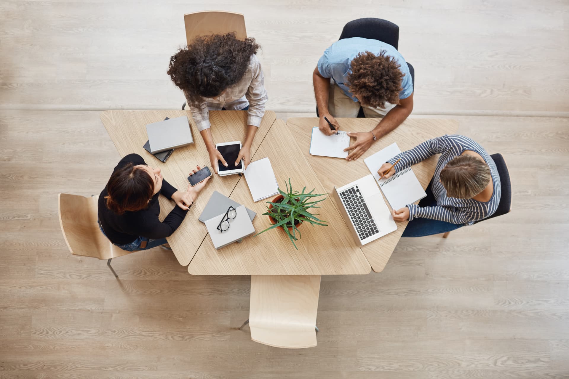 Equipo colaborando alrededor de una mesa de trabajo